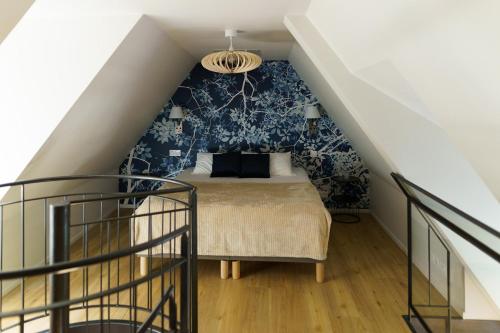 a bedroom with a bed with a blue wall at La Chaumière Roz-Aven in Pont-Aven