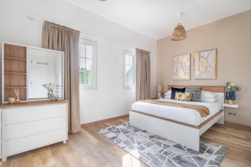 a bedroom with a bed and a dresser and windows at GuestReady - Springs Serenity near Golf Club in Dubai