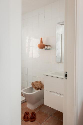 a white bathroom with a toilet and a sink at Bungalows El Arenal in Jávea