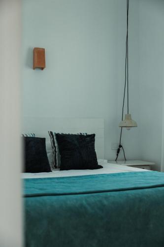 a bedroom with a bed with blue sheets and pillows at Los Bungalows Del Arenal in Jávea