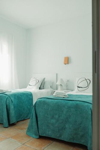 two beds in a room with green and white at Los Bungalows Del Arenal in Jávea