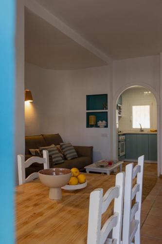 a living room with a couch and a table and chairs at Los Bungalows Del Arenal in Jávea