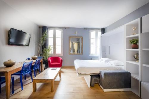 une chambre avec un lit, une table et des chaises dans l'établissement Charmant studio au centre ville, à Bordeaux