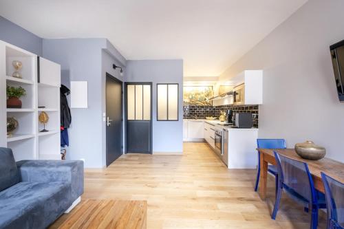 - une cuisine et un salon avec un canapé bleu et une table dans l'établissement Charmant studio au centre ville, à Bordeaux