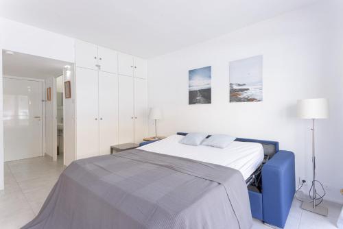 ein weißes Schlafzimmer mit einem blauen Bett und weißen Schränken in der Unterkunft GuestReady - Cannes Delight near Mouré Rouge Port in Cannes