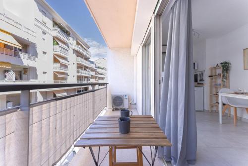eine Holzbank auf dem Balkon eines Gebäudes in der Unterkunft GuestReady - Cannes Delight near Mouré Rouge Port in Cannes