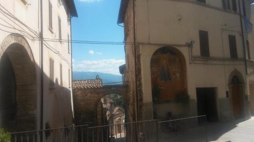 an alley between two buildings with a mountain in the background at Residenza Le Volte Degli Angeli in Spello