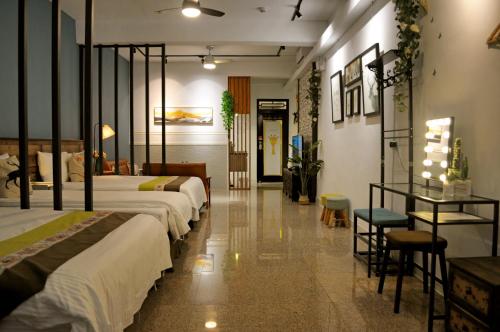 una habitación de hotel con 2 camas y una mesa con sillas en Lu-Kang Traveler Inns, en Lukang