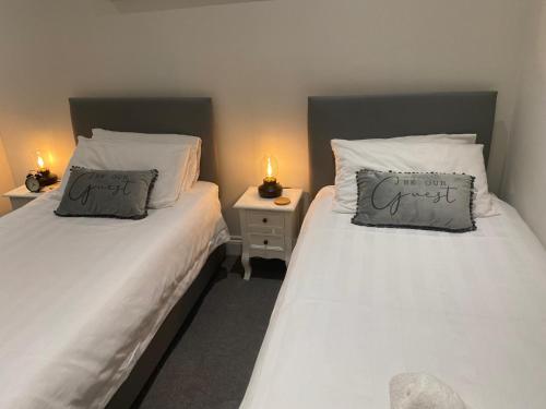 - 2 lits jumeaux dans une chambre avec 2 lampes dans l'établissement Flat 2 ,559 Wimborne Road, à Bournemouth