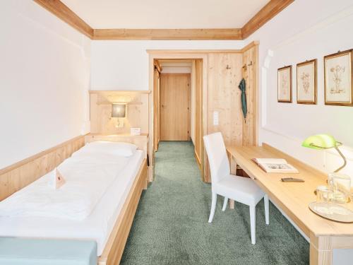 a hospital room with a bed and a desk at Genuss - und Vitalhotel Moisl in Abtenau