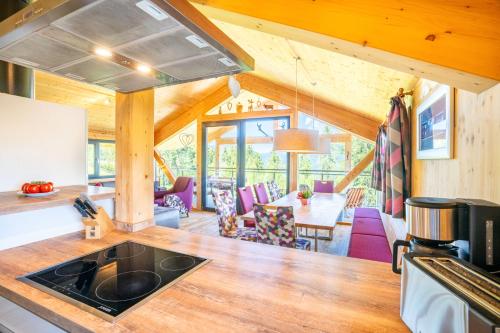 a kitchen and living room in a log cabin at Alpenchalets Reiteralm by ALPS RESORTS in Schladming