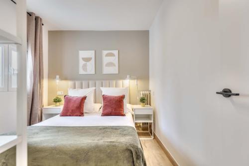 een slaapkamer met een groot bed met 2 rode kussens bij Metropolitano en Madrid in Madrid