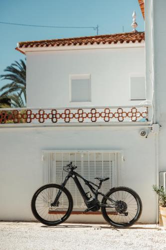 a bike parked in front of a white building at Los Bungalows Del Arenal in Jávea
