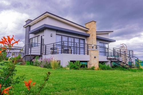 a house on a hill with a green yard at Tufaha Resort in Nanyuki