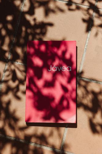 a pink sign with the word jveno on a wall at Los Bungalows Del Arenal in Jávea