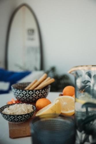 a table with two bowls of food and some oranges at Los Bungalows Del Arenal in Jávea