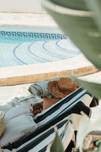 a person laying in a hammock next to a swimming pool at Los Bungalows Del Arenal in Jávea