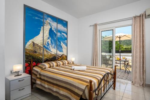 a bedroom with a bed with a large painting on the wall at Pervolia Studios Near Airport in Kremasti