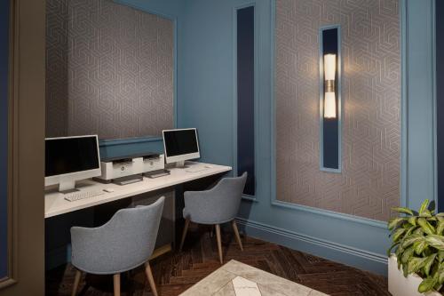 an office with a desk with two monitors and two chairs at Courtyard by Marriott Edinburgh in Edinburgh