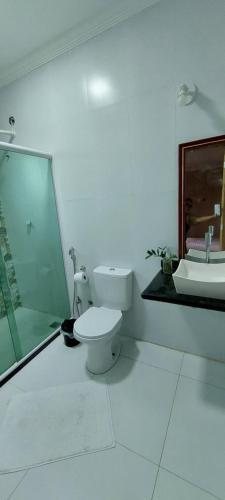 uma casa de banho branca com um WC e um lavatório em Cantinho Top em Búzios