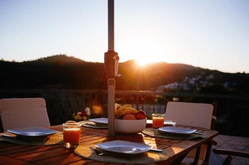 a wooden table with a bowl of fruit and the sunset at Casa de Mellares in Melres