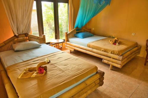 two beds in a room with two at Bunga Bungalows in Gili Meno