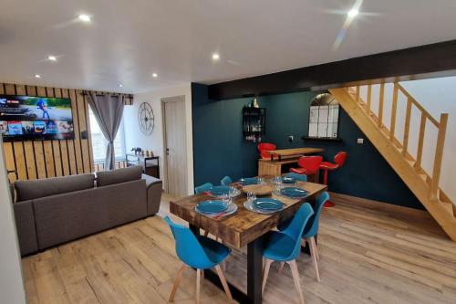 - un salon avec une table en bois et des chaises bleues dans l'établissement Logement Moderne Mont-Saint-Michel, à Saint-James