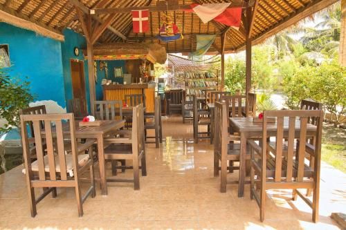 a dining room with wooden tables and chairs in a restaurant at Bunga Bungalows in Gili Meno