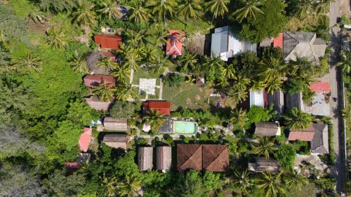 an overhead view of a yard with palm trees and houses at Bunga Bungalows in Gili Meno