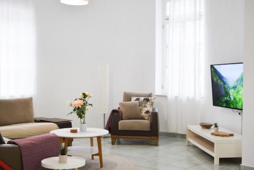 a living room with two chairs and a tv at Ixia Manor House in Ixia