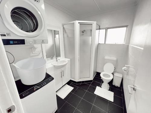 a white bathroom with a sink and a toilet at Gladstone Gem 9 - Suva CBD 2 Bedroom Apartment in Suva