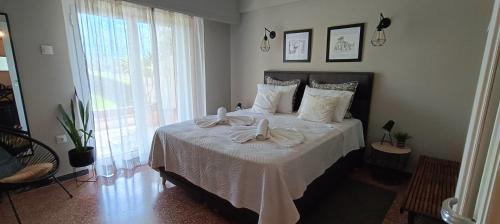 um quarto com uma cama grande com lençóis brancos e almofadas brancas em Sea&Sun Glyfada Apartment em Atenas