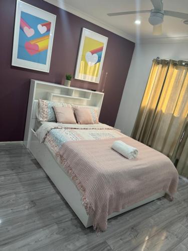 a bedroom with a bed with pink walls at Fully furnished 4 Bedrooms House located in Fraser Rise in Sydenham