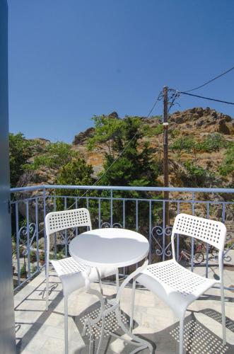 a white table and chairs on a balcony at Studio Kastro I in Mirina