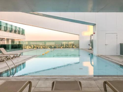 a swimming pool in a building with a glass wall at GuestReady - Exuberance and refinement in Dubai