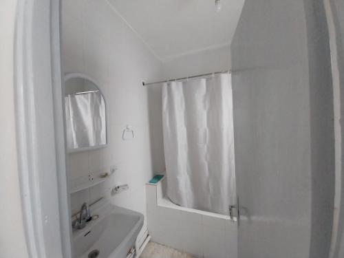 biała łazienka z prysznicem i umywalką w obiekcie L'escale w mieście Tunis