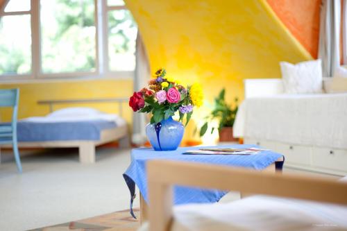 a blue vase with flowers on a table in a room at Hotel Georg in Witten