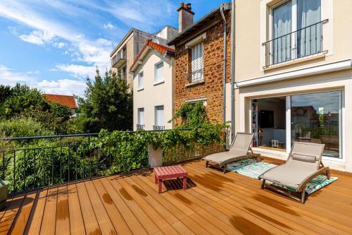 a balcony with two chairs and a wooden deck at GuestReady - Exquisite and calm getaway in Nogent-sur-Marne
