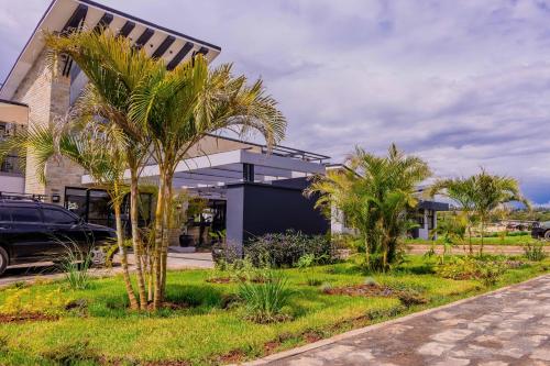 a building with palm trees in front of it at Tufaha Resort in Nanyuki