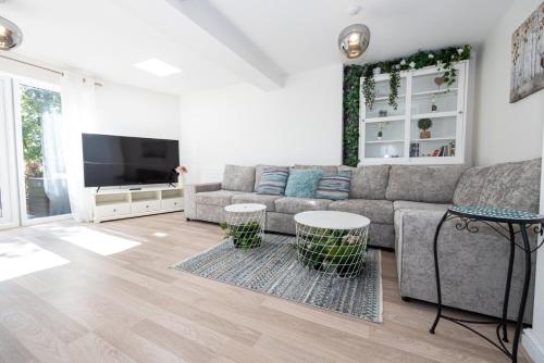 a living room with a couch and a flat screen tv at GuestReady - A Haven by the River in Manchester