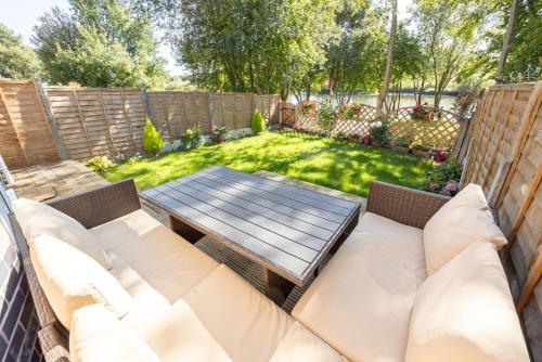 a backyard with a wooden table and a picnic table at GuestReady - A Haven by the River in Manchester