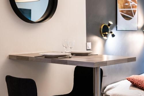 une table avec des verres et un miroir mural dans l'établissement Central Part-Dieu - Appartement 2, à Lyon