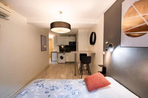 une petite chambre avec un lit et une cuisine dans l'établissement Central Part-Dieu - Appartement 2, à Lyon