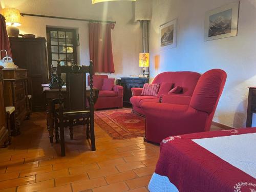 a living room with red furniture and a bed at La maison de Madeleine in Castellane