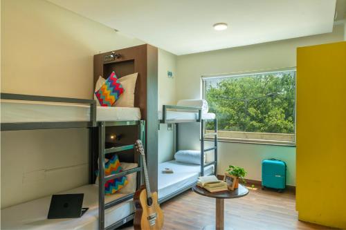 a room with two bunk beds and a guitar at goSTOPS Delhi in New Delhi