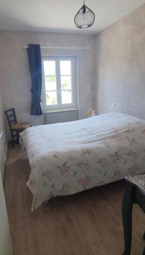 une chambre avec un grand lit et une fenêtre dans l'établissement le petit monnet, à Moyaux