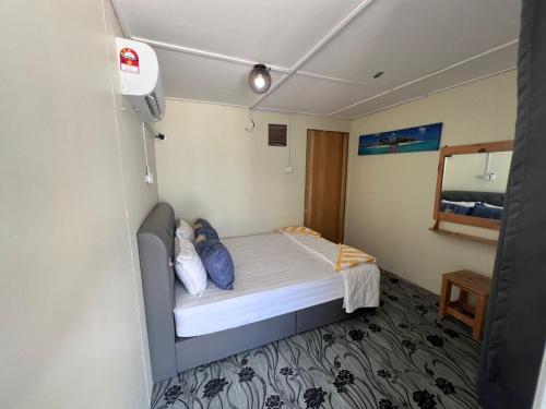 małą sypialnię z łóżkiem w pokoju w obiekcie Khafii House w mieście Kampong Pasir Panjang