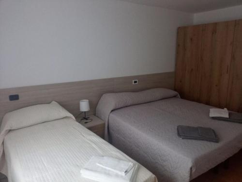a hotel room with two beds and a lamp at Il Ricjûl in Muina