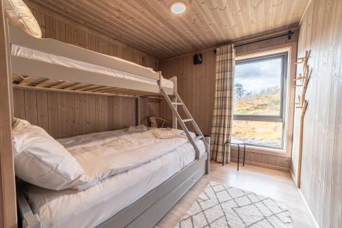 Litera en habitación con ventana en Fjellsætra Sunnmøre Hideaway, Mountain View & Private Sauna en Sykkylven