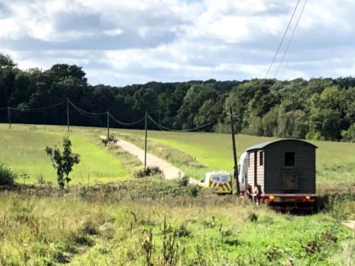 a truck and a car on a road in a field at Whittlewood Shepherd's Hut in Silverstone, Cosy, Rural, Views in Silverstone